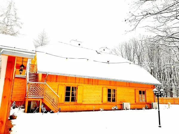 ośnieżony drewniany dom, ciepłe barwy