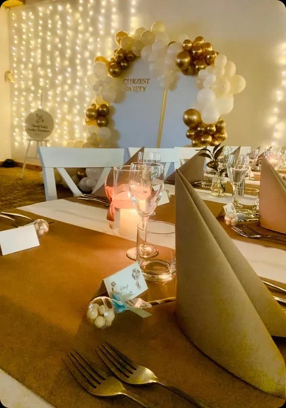 zastawiony stół, złote serwety, ciepłe oświetlenie