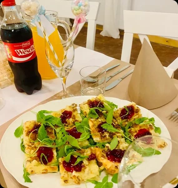 tapasy, coca-cola i kieliszki na stole, przy stole białe krzesła